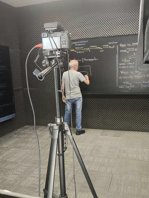 Professor gravando aula no estúdio com a câmera montada no tripé